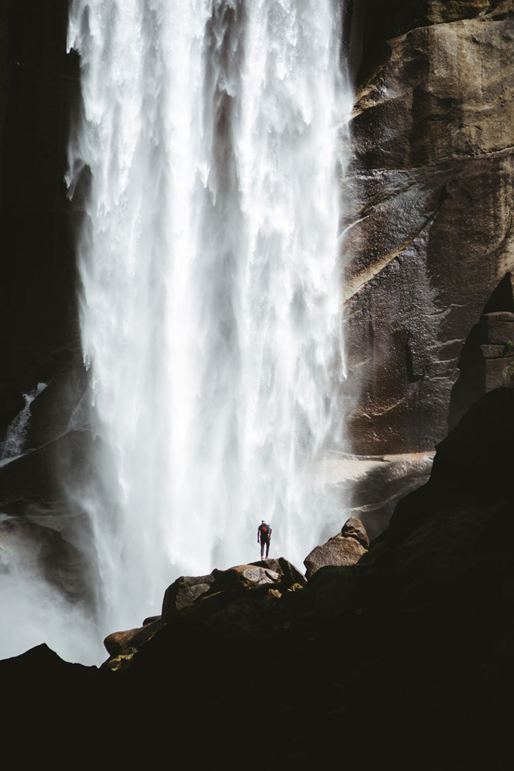 Man stands at the base of Vernal Falls in Yosemite National Park